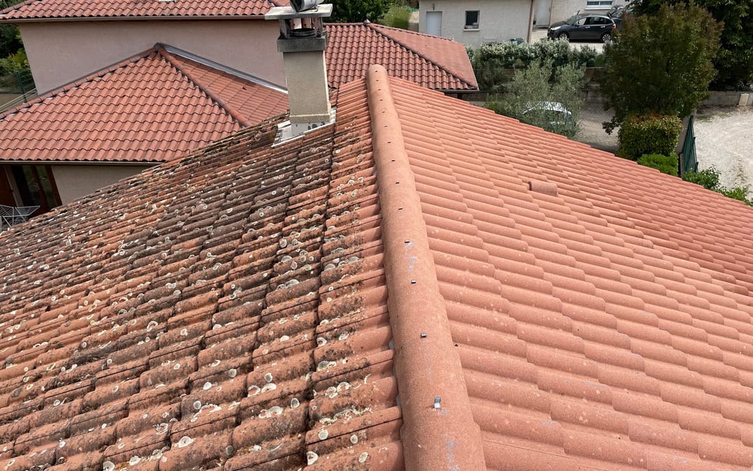Toiture en tuiles béton : versant gauche encore couvert de lichens, versant droit après démoussage